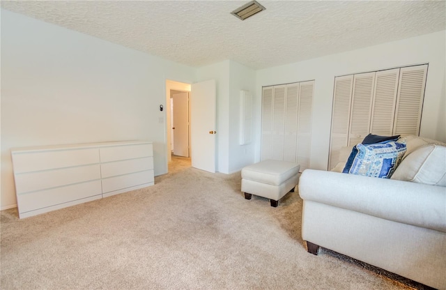 living area featuring light carpet and a textured ceiling