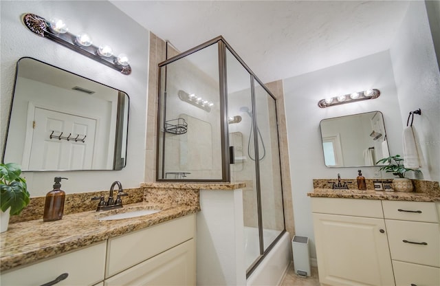 bathroom with vanity and combined bath / shower with glass door