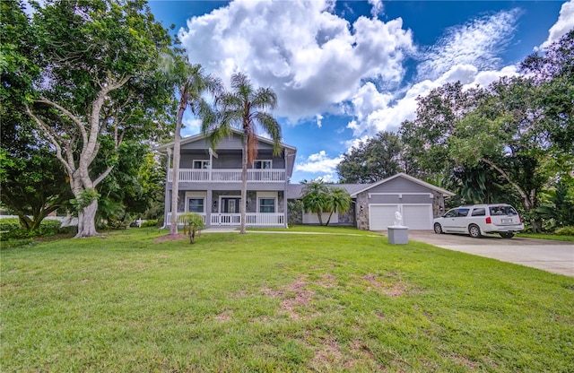 view of front of property with a front lawn, covered porch, and a garage