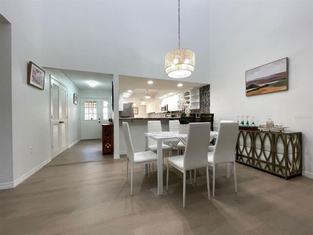 dining room with a high ceiling, a chandelier, and dark hardwood / wood-style flooring