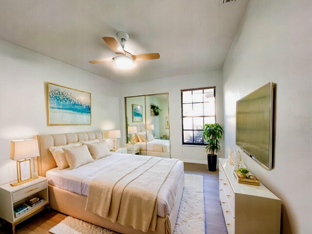 bedroom with ceiling fan, hardwood / wood-style flooring, and a closet