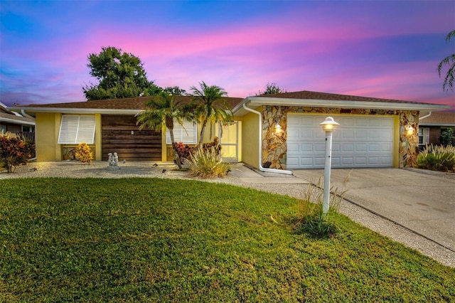 single story home featuring a yard and a garage