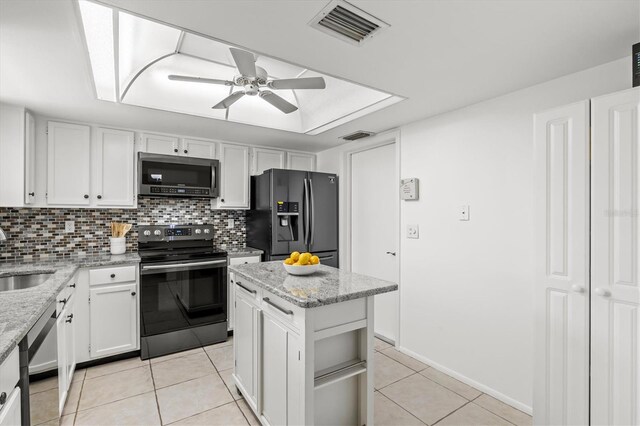 kitchen featuring a center island, tasteful backsplash, white cabinetry, appliances with stainless steel finishes, and ceiling fan