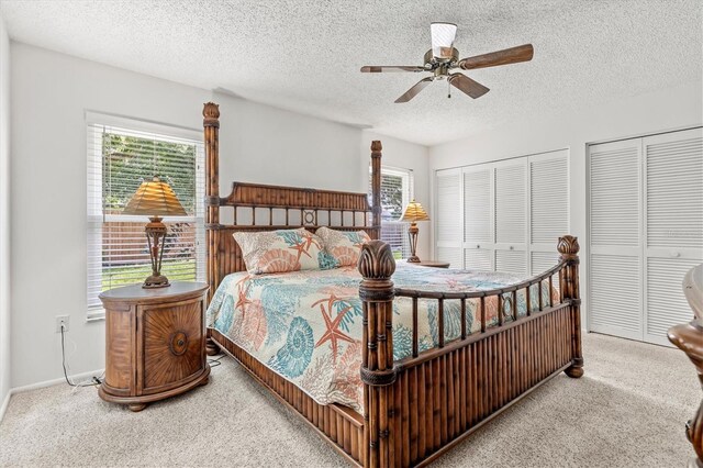 bedroom featuring ceiling fan, a textured ceiling, carpet, and multiple windows