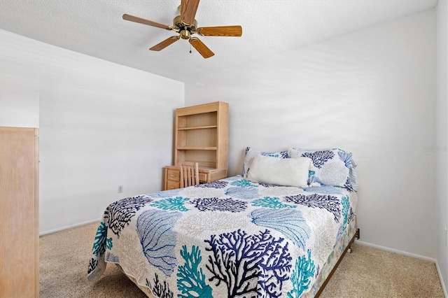 carpeted bedroom with ceiling fan and a textured ceiling