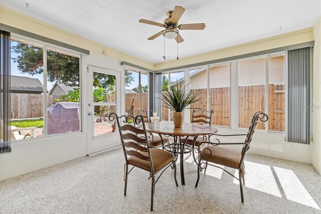 sunroom featuring ceiling fan and plenty of natural light