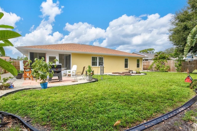 back of house featuring a lawn and a patio