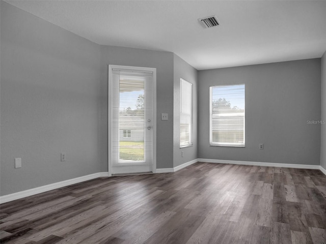 unfurnished room with dark wood-type flooring