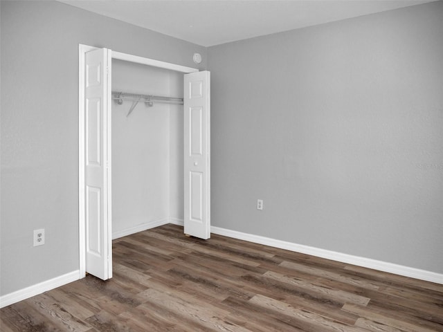 unfurnished bedroom featuring dark wood-type flooring and a closet