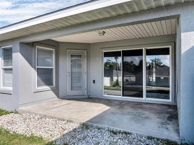 view of exterior entry featuring a patio