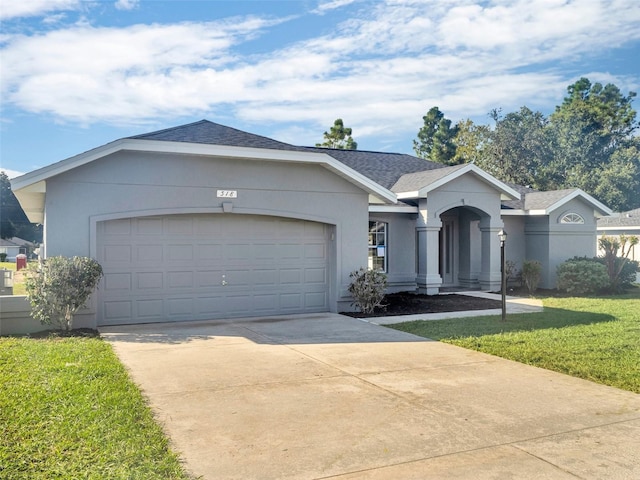 ranch-style house featuring a garage and a front lawn