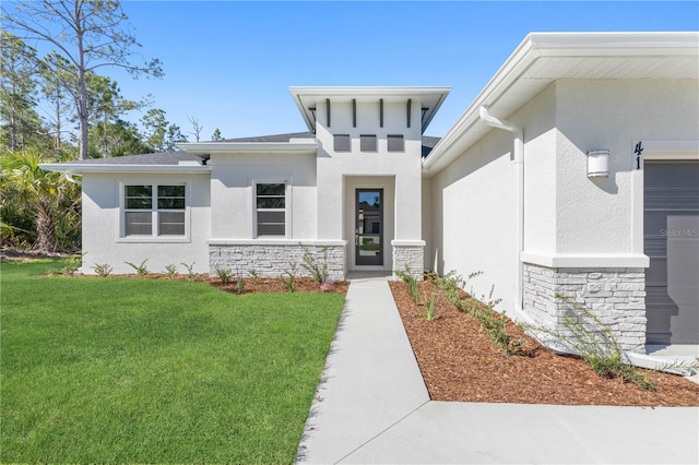 view of exterior entry with a lawn and a garage