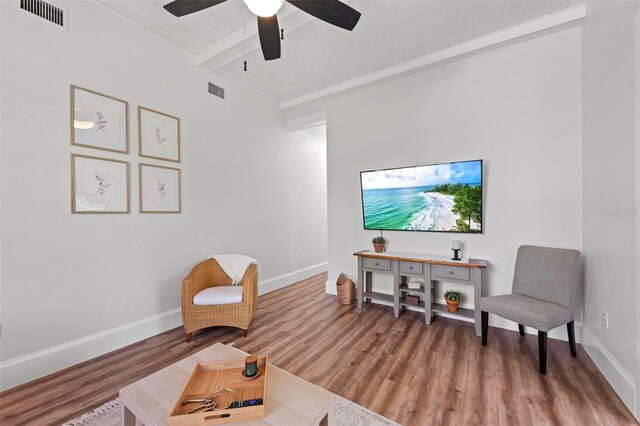 sitting room with beamed ceiling, hardwood / wood-style flooring, and ceiling fan