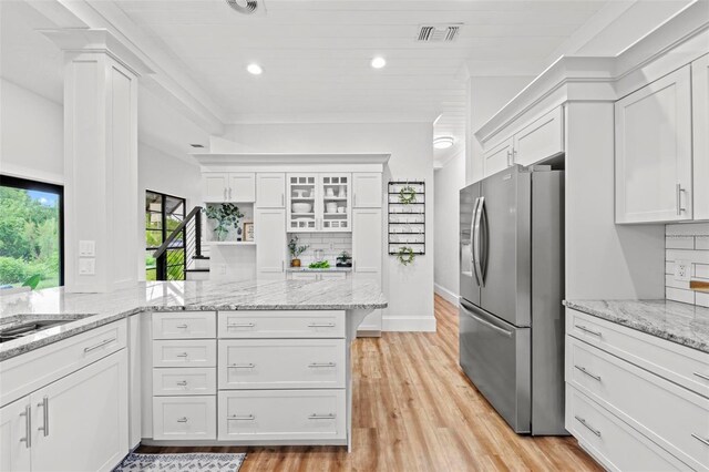 kitchen featuring white cabinetry, light stone countertops, and stainless steel refrigerator with ice dispenser