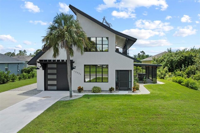 rear view of property with a lawn, a sunroom, and a garage