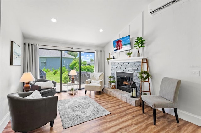 living room with a fireplace, hardwood / wood-style flooring, vaulted ceiling, and an AC wall unit