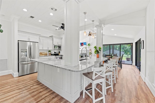 kitchen with hanging light fixtures, ceiling fan, light stone counters, white cabinetry, and stainless steel appliances