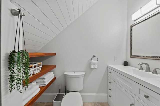 bathroom featuring vanity, toilet, baseboards, wooden ceiling, and vaulted ceiling