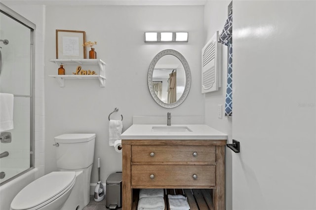 bathroom with vanity, enclosed tub / shower combo, and toilet