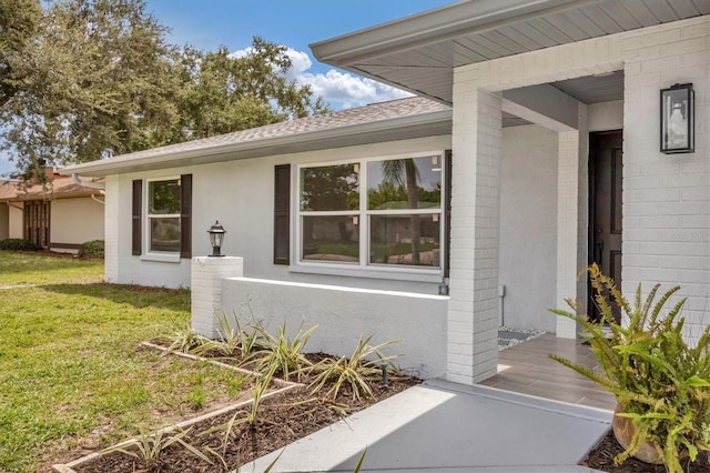 view of exterior entry with a yard