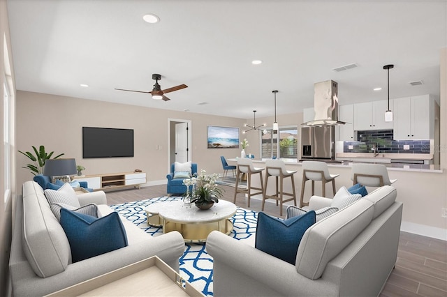 living room featuring dark hardwood / wood-style floors and ceiling fan with notable chandelier