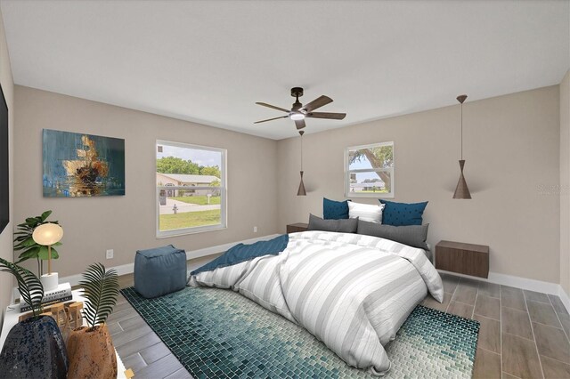 bedroom with ceiling fan, multiple windows, and hardwood / wood-style floors