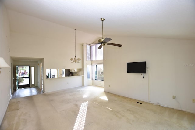 unfurnished living room with carpet flooring, ceiling fan with notable chandelier, and high vaulted ceiling