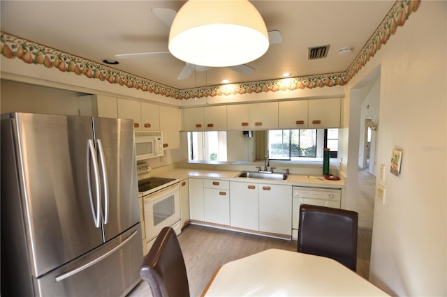 kitchen with white cabinetry, sink, ceiling fan, dark hardwood / wood-style floors, and white appliances