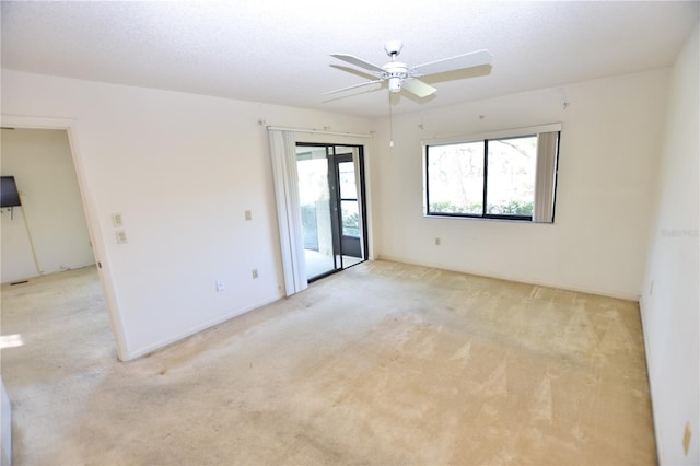 carpeted empty room with ceiling fan and a textured ceiling