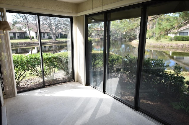 unfurnished sunroom with a water view