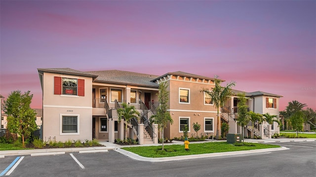 view of front of property with a balcony and central AC unit