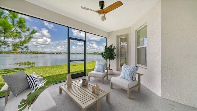 sunroom / solarium featuring a water view and ceiling fan