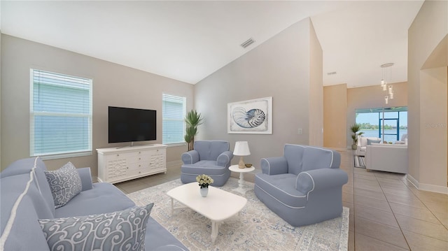 living room featuring high vaulted ceiling and tile patterned floors