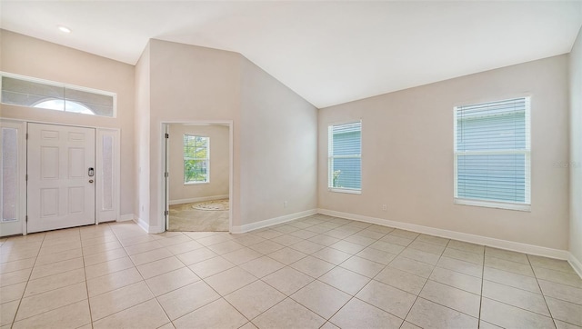 entrance foyer with lofted ceiling and light tile patterned flooring