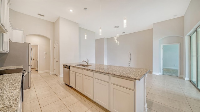 kitchen featuring dishwasher, a kitchen island with sink, hanging light fixtures, white cabinetry, and light stone counters