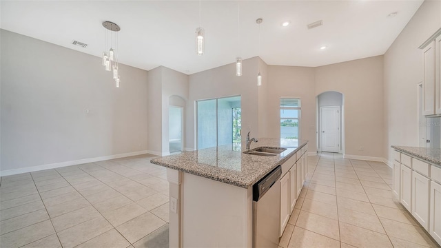 kitchen featuring light stone counters, sink, pendant lighting, a kitchen island with sink, and stainless steel dishwasher