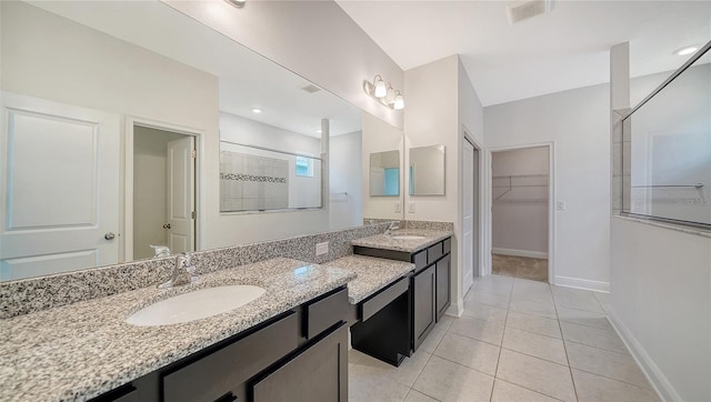 bathroom featuring tiled shower, tile patterned flooring, and vanity