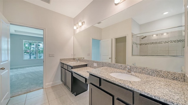 bathroom with tiled shower, vanity, and tile patterned floors