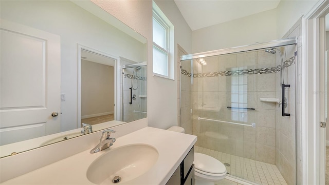 bathroom featuring vanity, toilet, and a shower with shower door