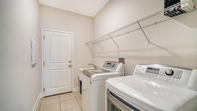 laundry room featuring washer and clothes dryer and light tile patterned flooring