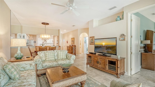 tiled living room featuring ceiling fan with notable chandelier