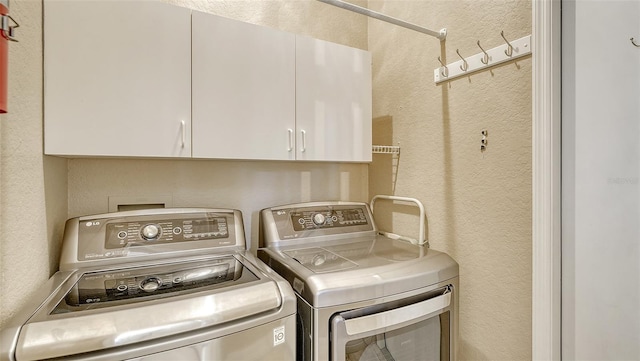 washroom with washing machine and dryer and cabinets