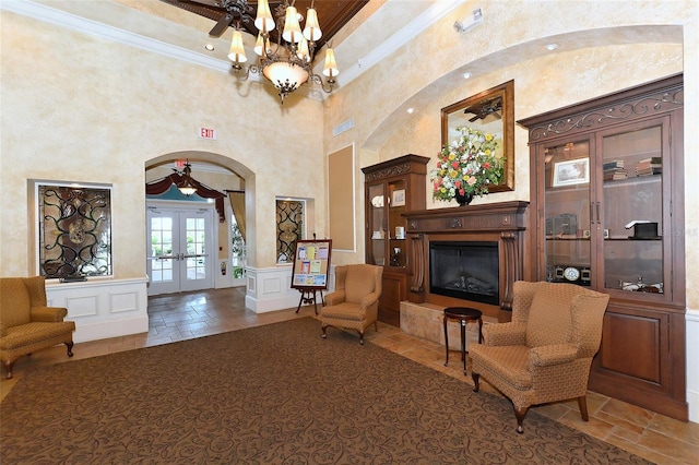 sitting room featuring french doors, crown molding, a high ceiling, and ceiling fan