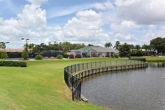 surrounding community with a water view and a yard