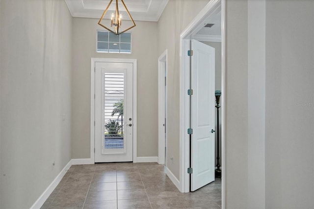 tiled entrance foyer with an inviting chandelier, baseboards, visible vents, and ornamental molding