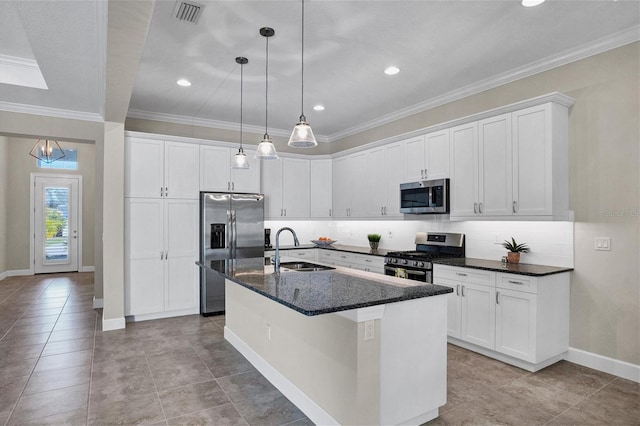 kitchen with a center island with sink, white cabinets, stainless steel appliances, and sink