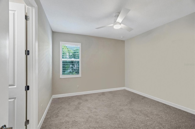 carpeted spare room with ceiling fan