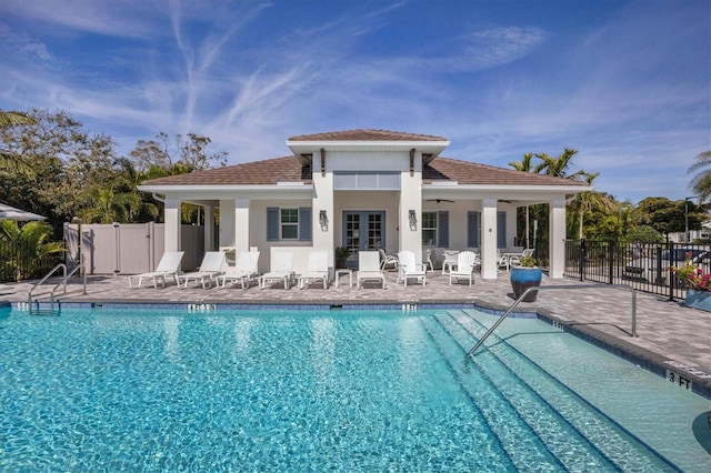 rear view of property with french doors, a community pool, ceiling fan, and a patio area