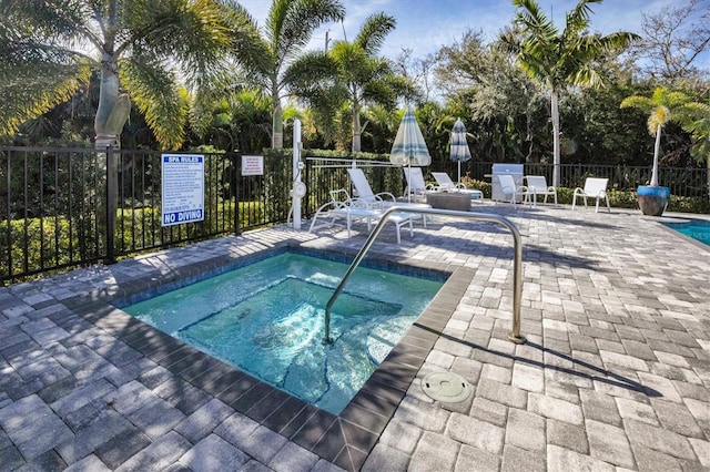 view of swimming pool with a patio area and a hot tub