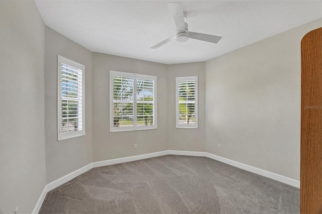 spare room featuring carpet flooring, ceiling fan, and a healthy amount of sunlight